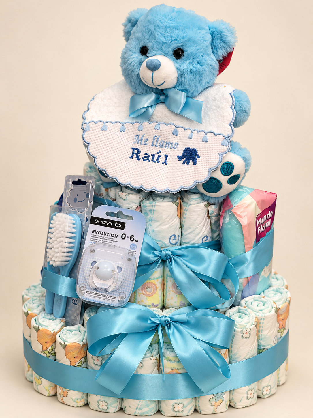 Tarta de pañales azul con osito y babero bordado